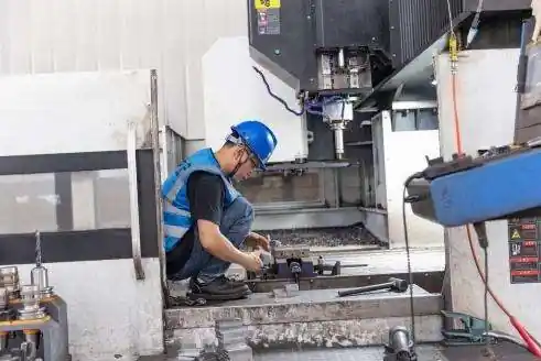 Operario preparando una pieza en un centro de mecanizado CNC de un socio de manufactura colaborador